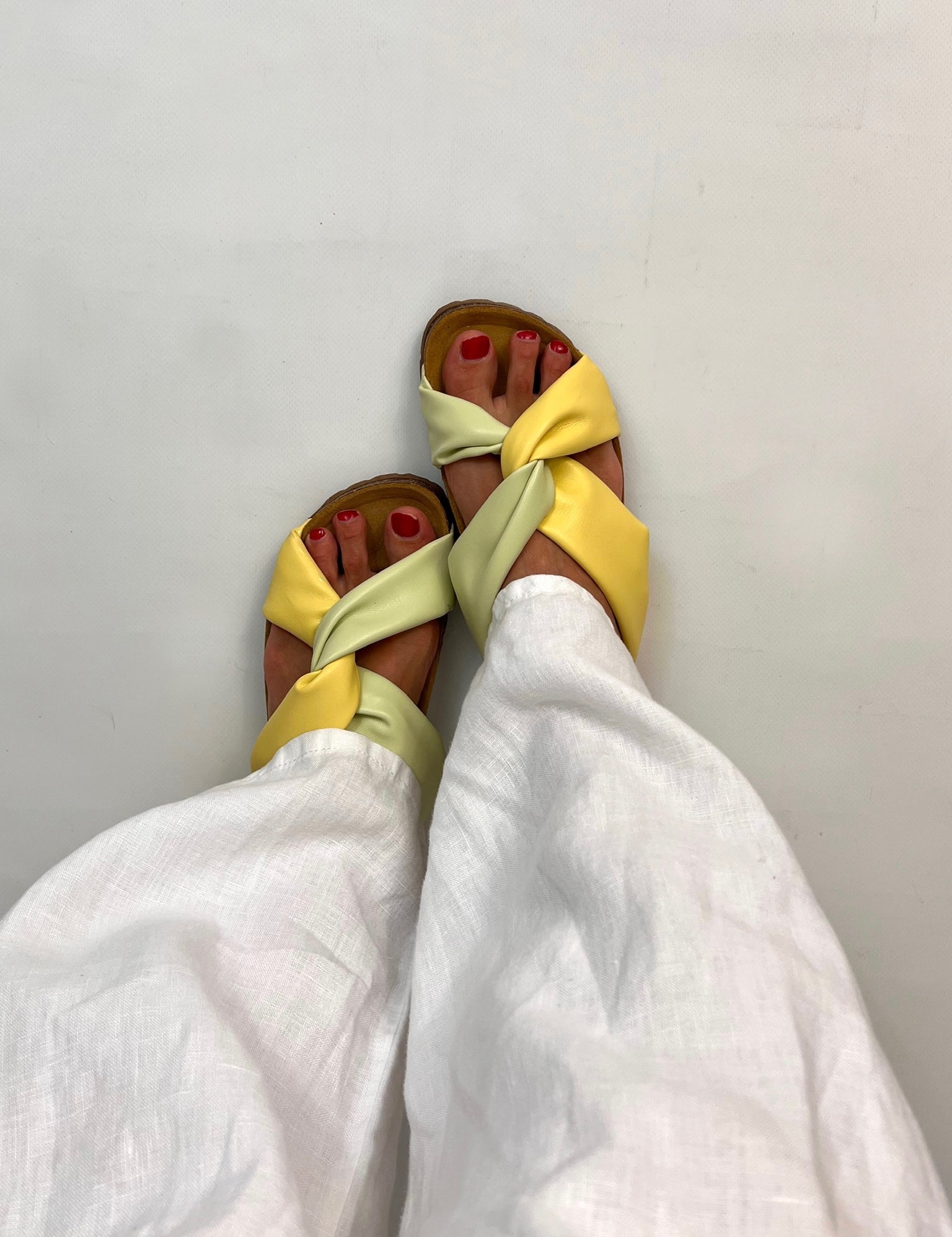 Momoc Calpe yellow green pastel knotted sandals worn front view white trousers cork sole sustainable Spain | Momoc Shoes Spain