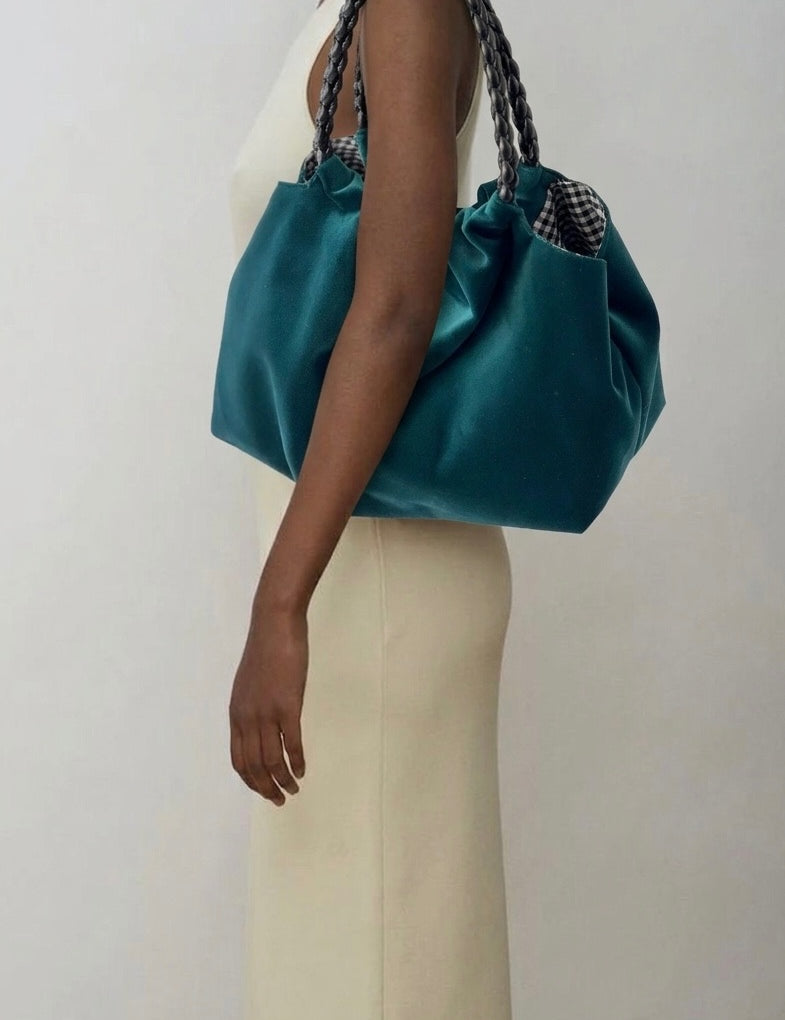 Momoc Lucrecia teal velvet bag black braided handle held by shoulder beige outfit | Momoc Shoes