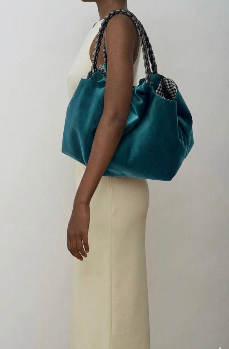 Momoc Lucrecia teal velvet bag black braided handle held by shoulder beige outfit | Momoc Shoes