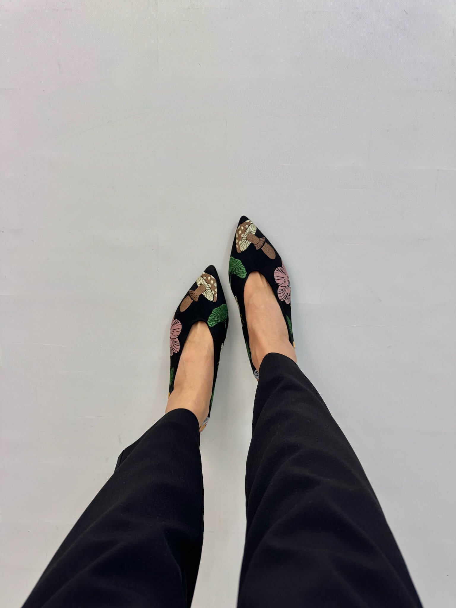 Multicolor embroidered ballet flats worn top view feet dark trousers | Momoc Shoes Spain