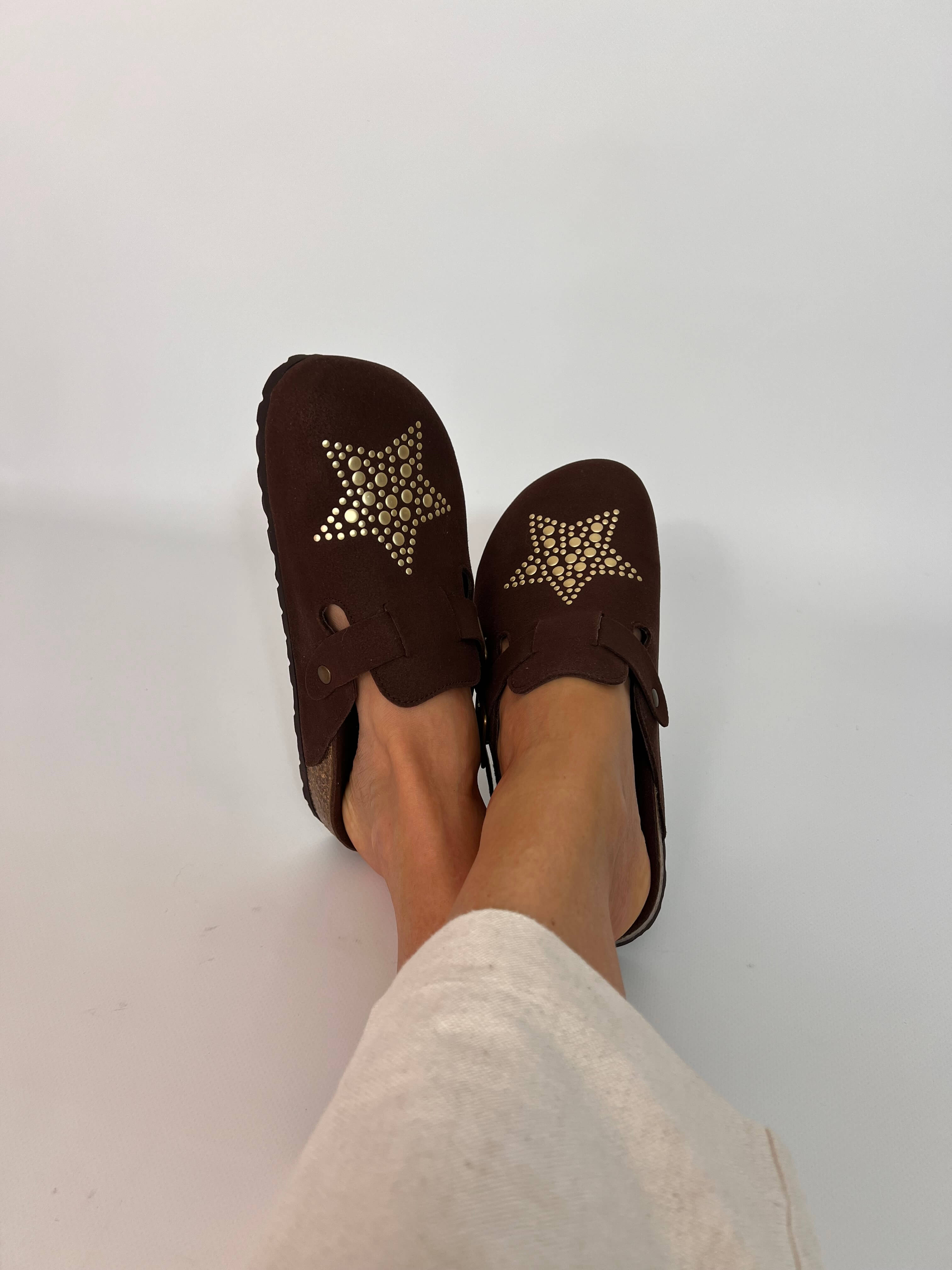 Momoc A Star Chocolate clogs worn side view white linen trousers gold metallic stars | Momoc Shoes Spain