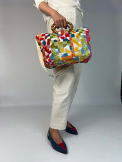 Momoc Frigiliana Mosaic Bamboo bag held by model white trousers bamboo handles outfit | Momoc Shoes