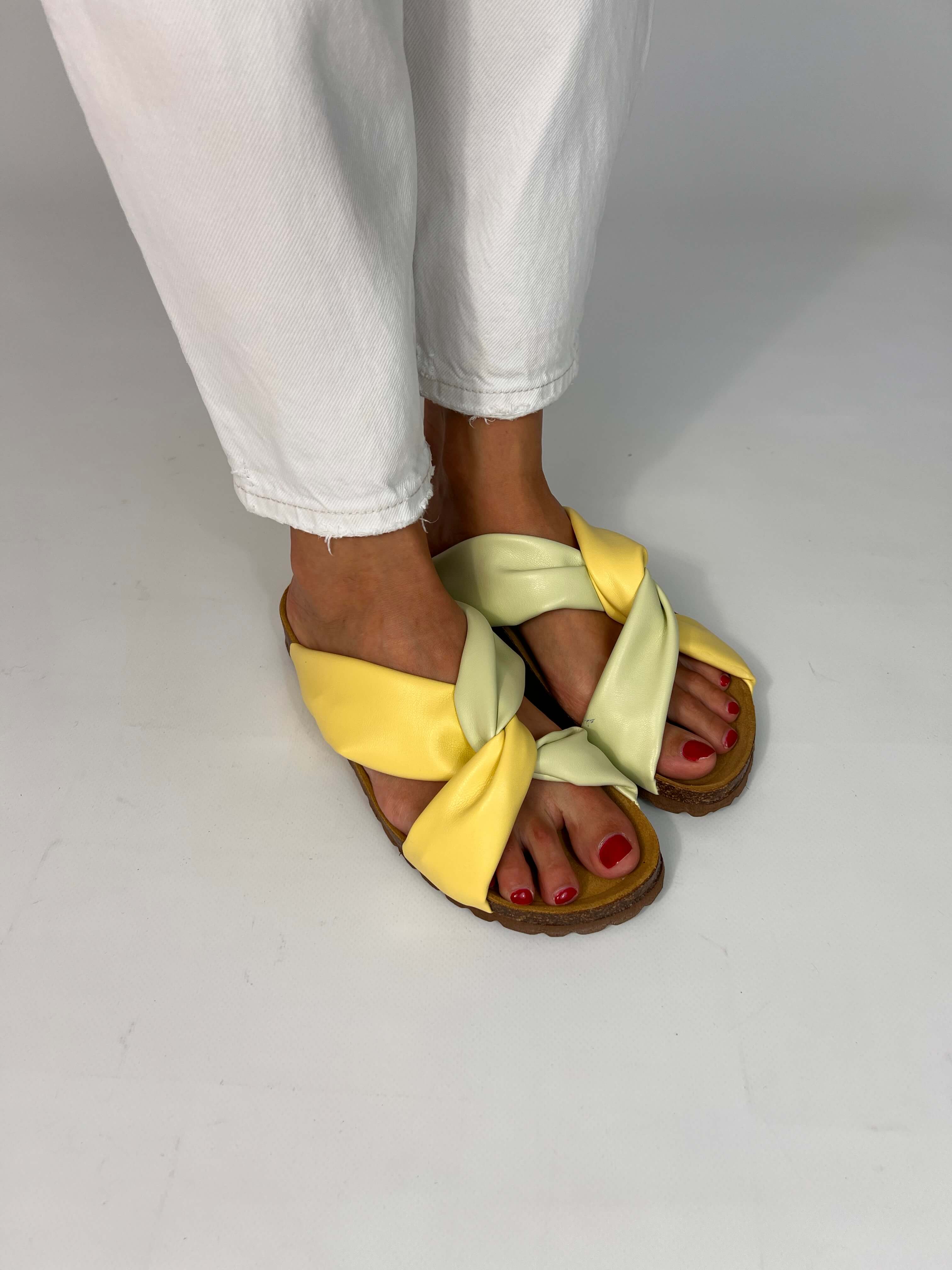 Momoc Calpe yellow pistachio pastel sandals worn side view white trousers cross strap design | Momoc Shoes Spain