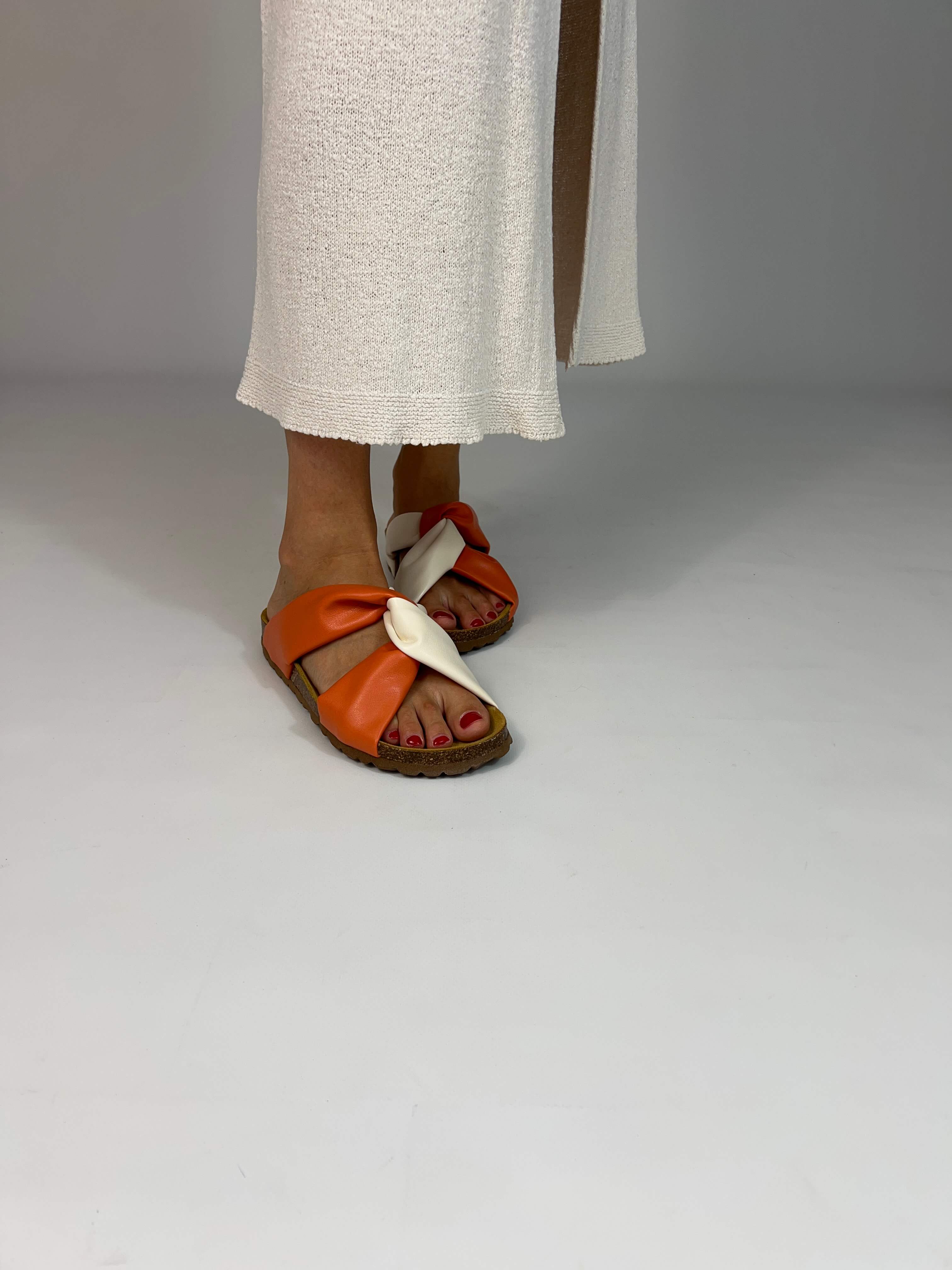 Momoc Calpe orange terracotta sandals worn side view white skirt cross strap design | Momoc Shoes Spain