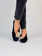 Momoc Le Marais two-tone ballet flats worn side view crossed leg grey jeans elegant | Momoc Shoes Spain