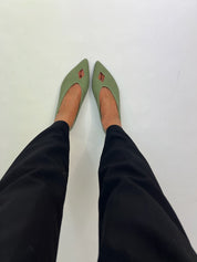 Momoc Elsa green ballet flats worn top view crossed feet black trousers rhombus cutout Spain | Momoc Shoes Spain