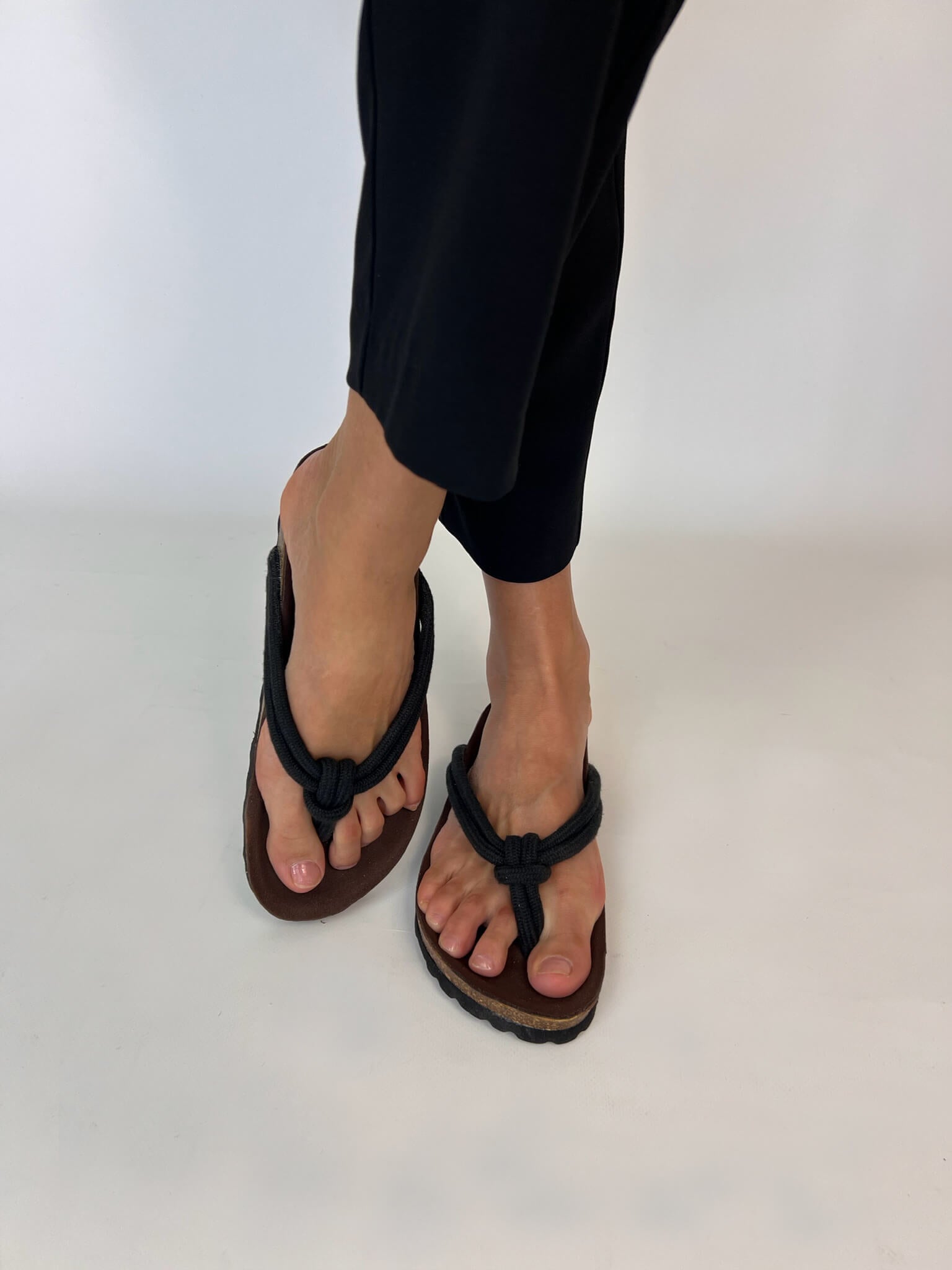 Momoc Javea black rope sandal worn side view black trousers white background sustainable | Momoc Shoes