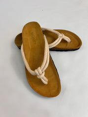 Momoc Javea natural thong sandal worn angled view white linen trousers knot detail | Momoc Shoes